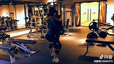 bodybuild girl cradle carries friend and squats